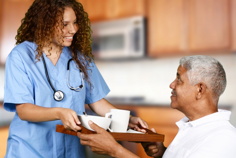 Health care worker helping an elderly man